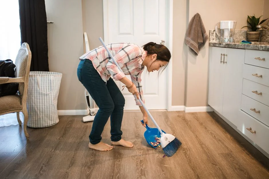 Cleaner using a vacuum in a stylish indoor setting, showcasing cleaning equipment and techniques.